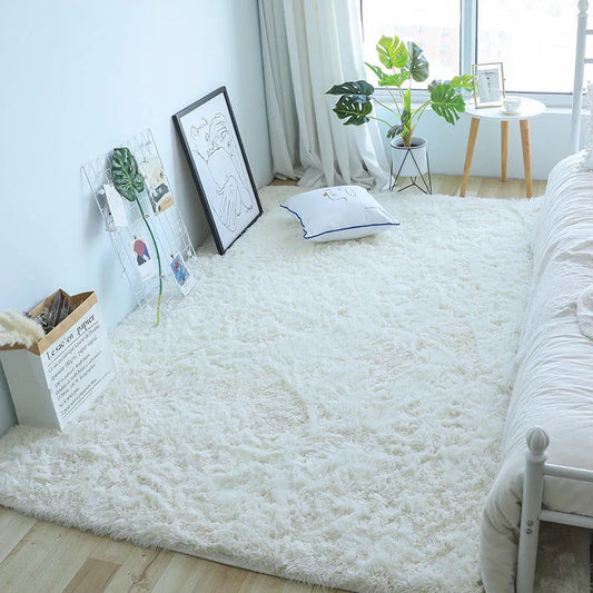 White fluffy rug in a room with a bed, plant, and decor items.