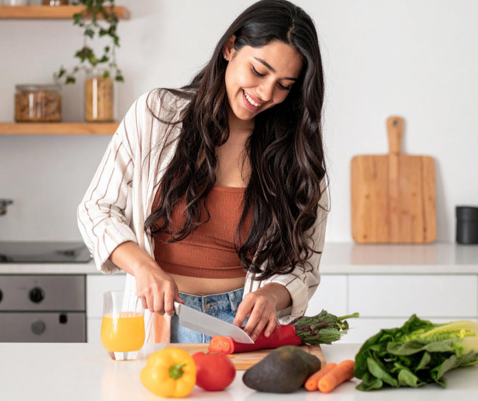 Image of a female cutting vegetables in a kitchen