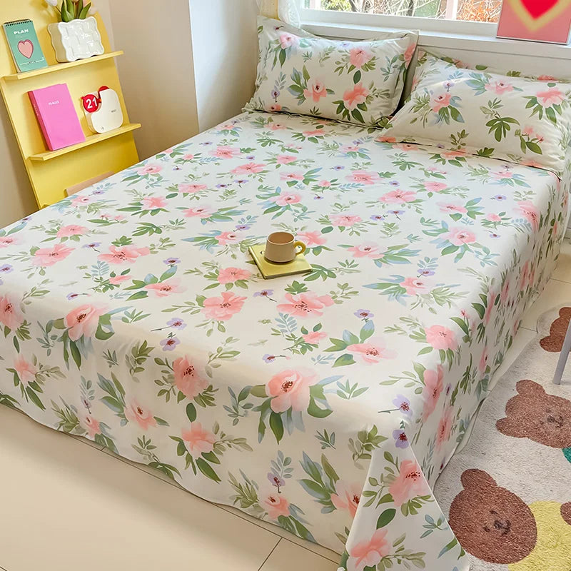 Floral patterned bedspread on a bed with pillows in a room setting.
