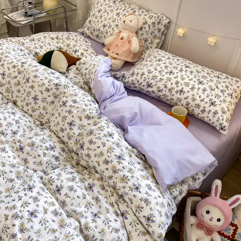 Floral bedding set on a bed with plush toys in a cozy bedroom.