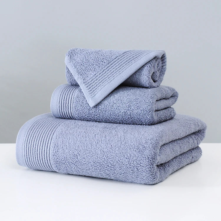 Stack of folded blue towels on a white surface with a gray background