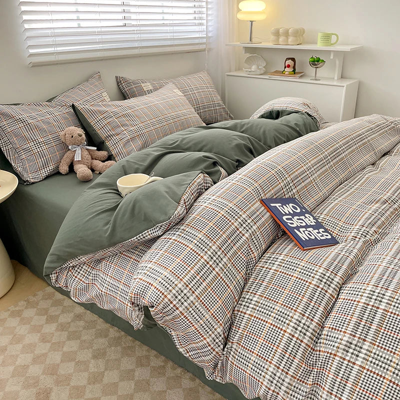 Bed with plaid and solid green bedding, teddy bear, and decorative items in a room.