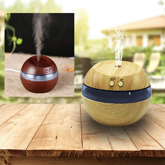 Two wooden diffusers on a wooden surface with a blurred outdoor background.
