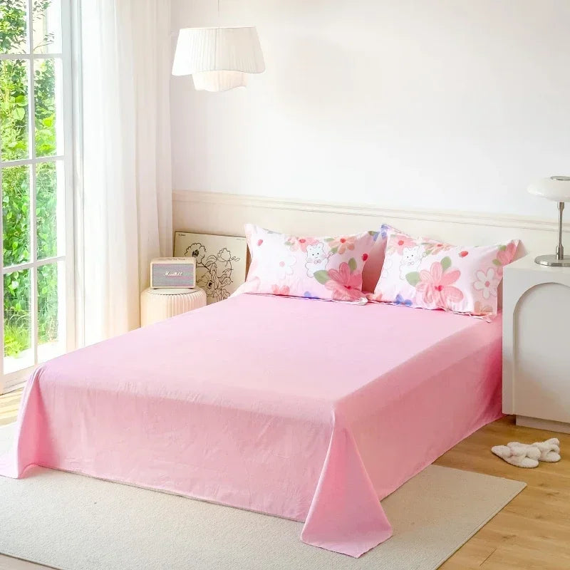 Bed with pink floral bedding in a bright bedroom