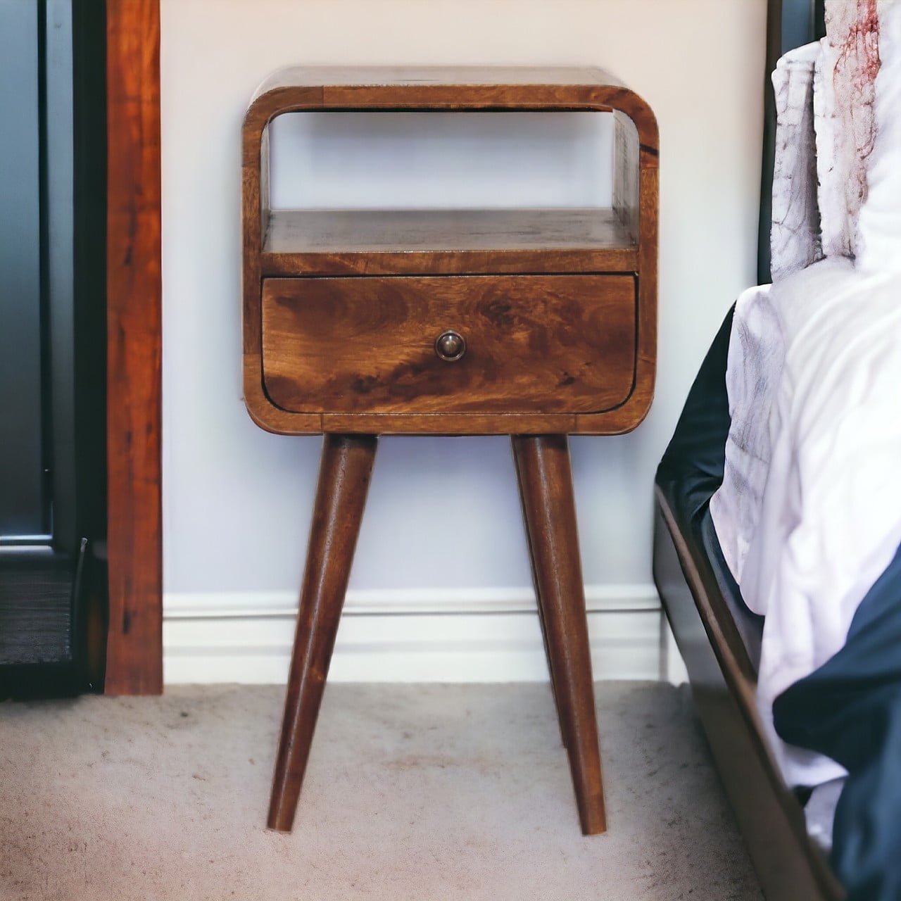 Mini Chestnut Curve Open Nightstand with 1 drawer, 1 open slot, and Nordic style legs. Positioned on a bedside