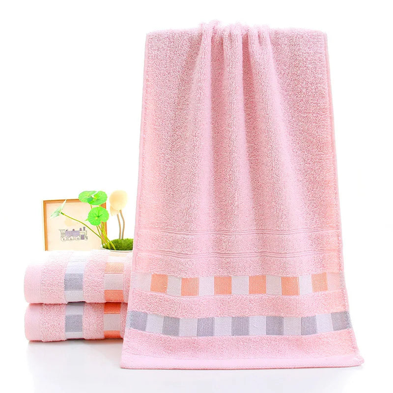 Pink towel with decorative border on a white background