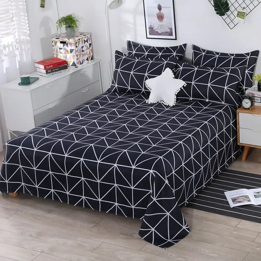 Bed with black and white geometric patterned bedding in a bedroom setting.