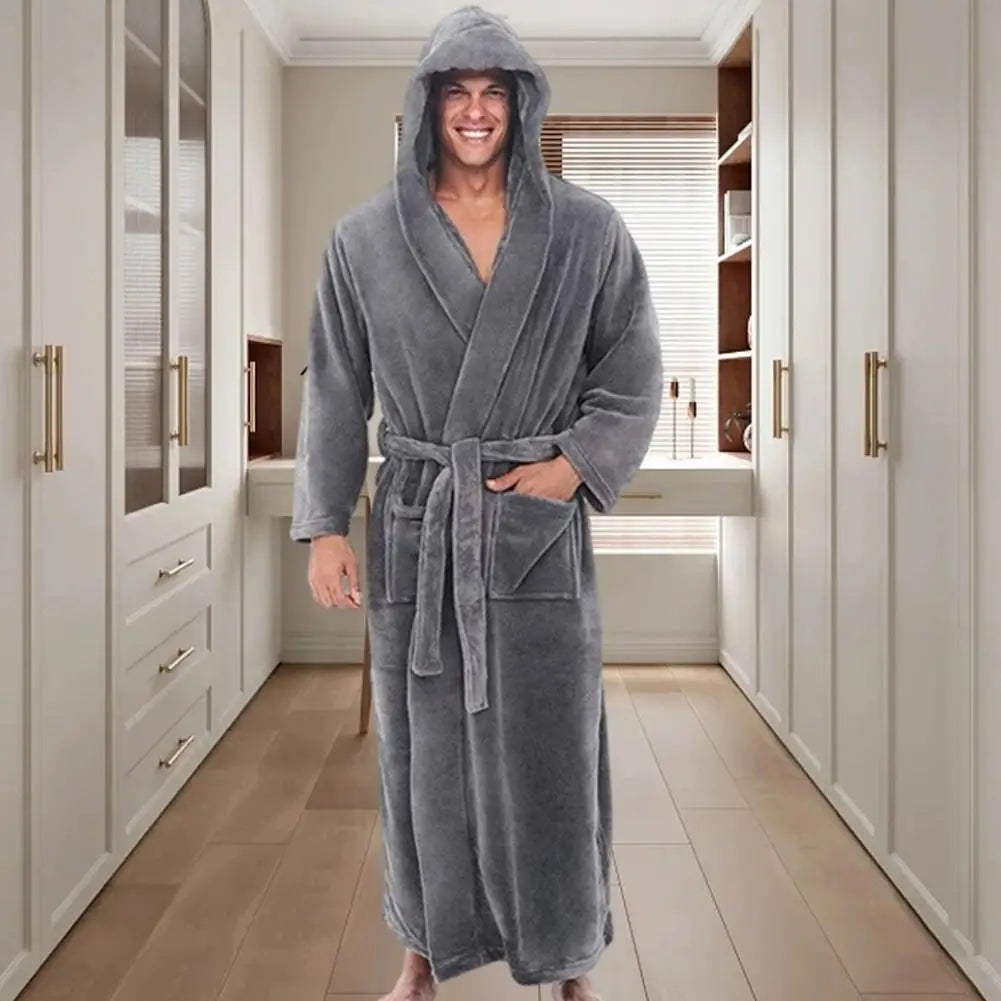 Man wearing a gray hooded robe in a modern bathroom.