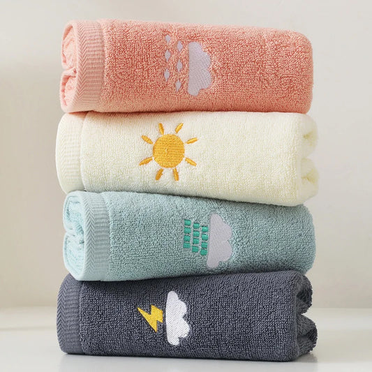 Stack of four colorful towels with embroidered designs on a light background