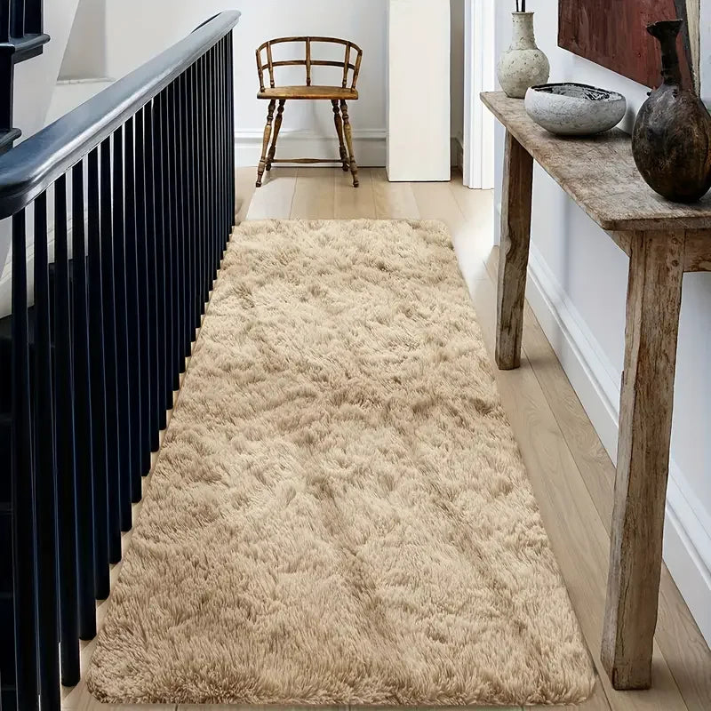Beige shaggy rug on a wooden floor with a black radiator and wooden bench in the background.
