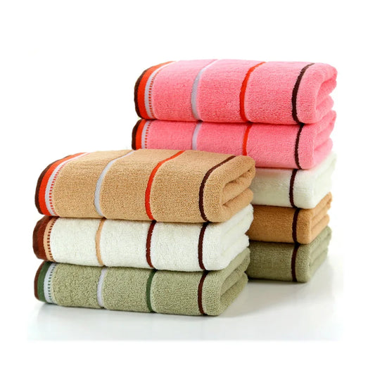 Stack of folded towels in pink, beige, white, and green on a white background