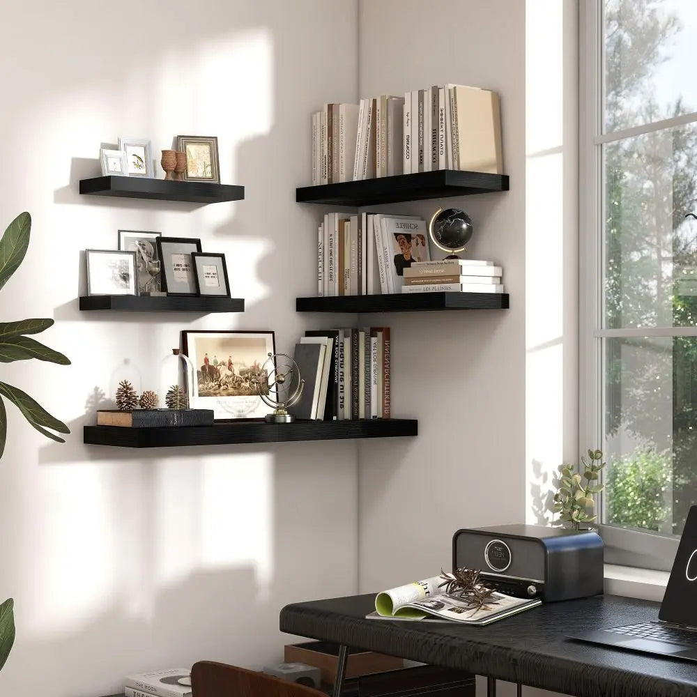 Modern home office with black floating shelves, books, and decor items.