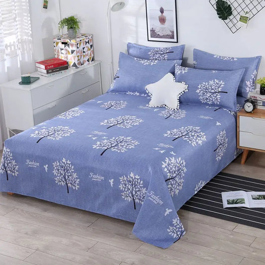 Blue floral patterned bedspread on a bed in a bedroom setting.