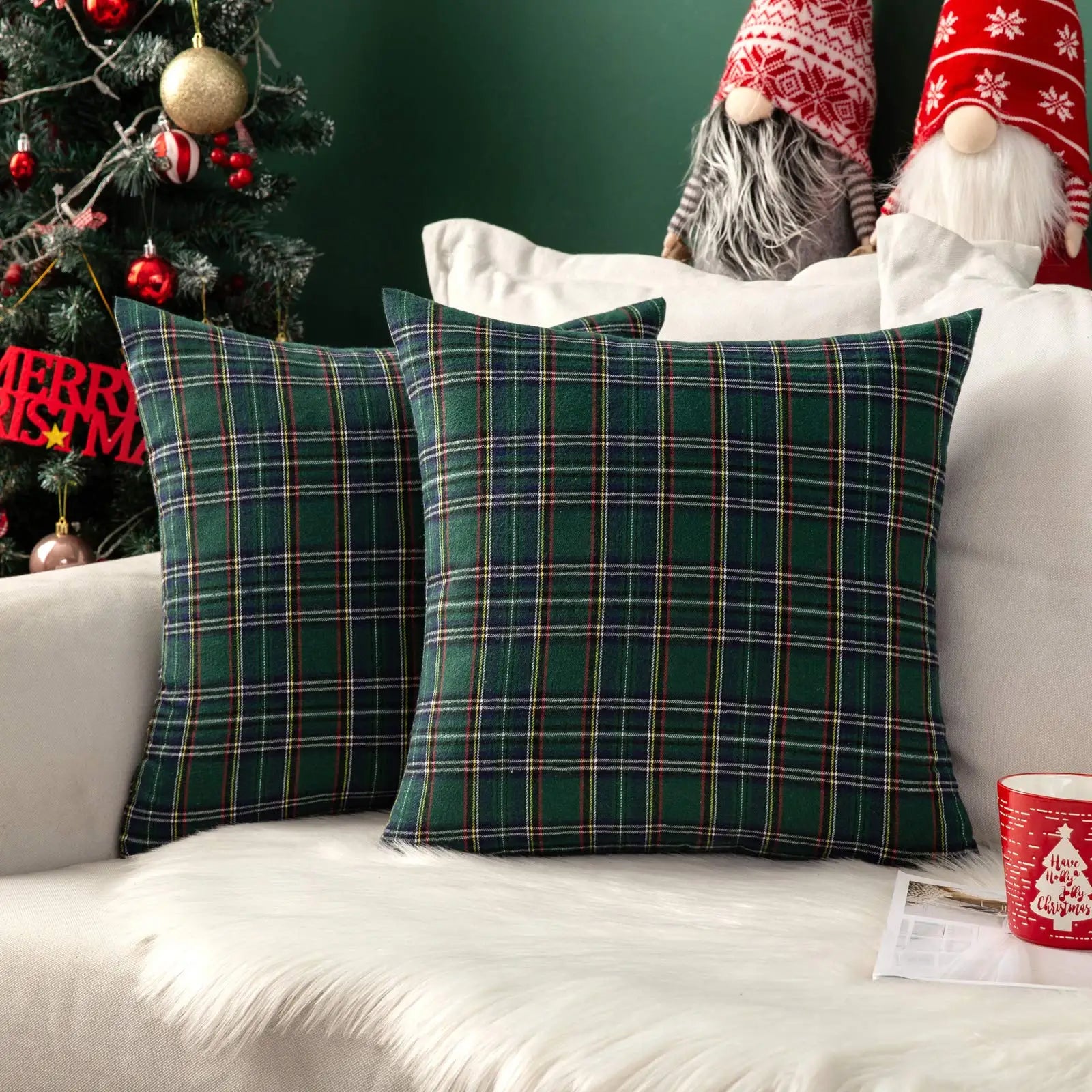 Plaid cushions on a sofa with Christmas decorations in the background
