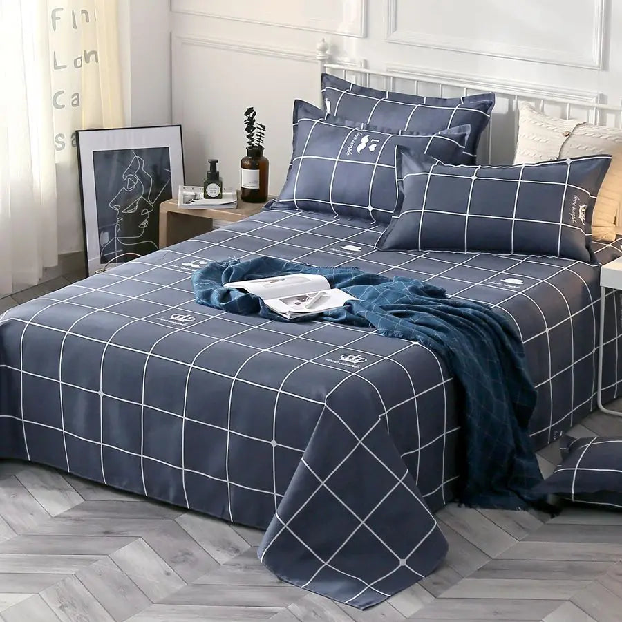 Blue checkered bedding set on a bed in a bedroom with a side table and decor items.