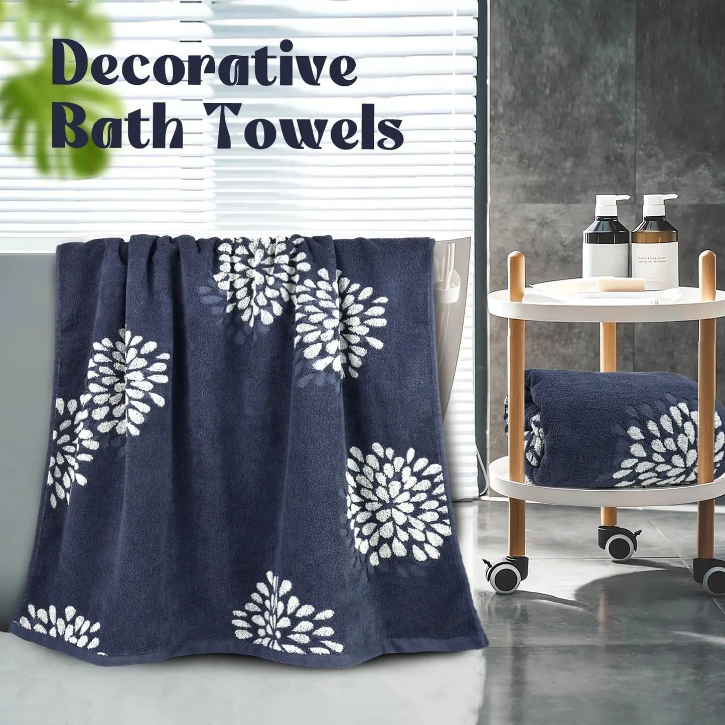 Decorative bath towel with white floral patterns on a blue background, placed on a surface with a blurred bathroom setting.
