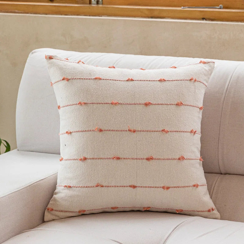 Decorative pillow with a subtle pattern on a beige sofa
