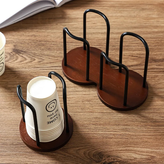 Two wooden cup holders with black metal stands on a wooden surface.