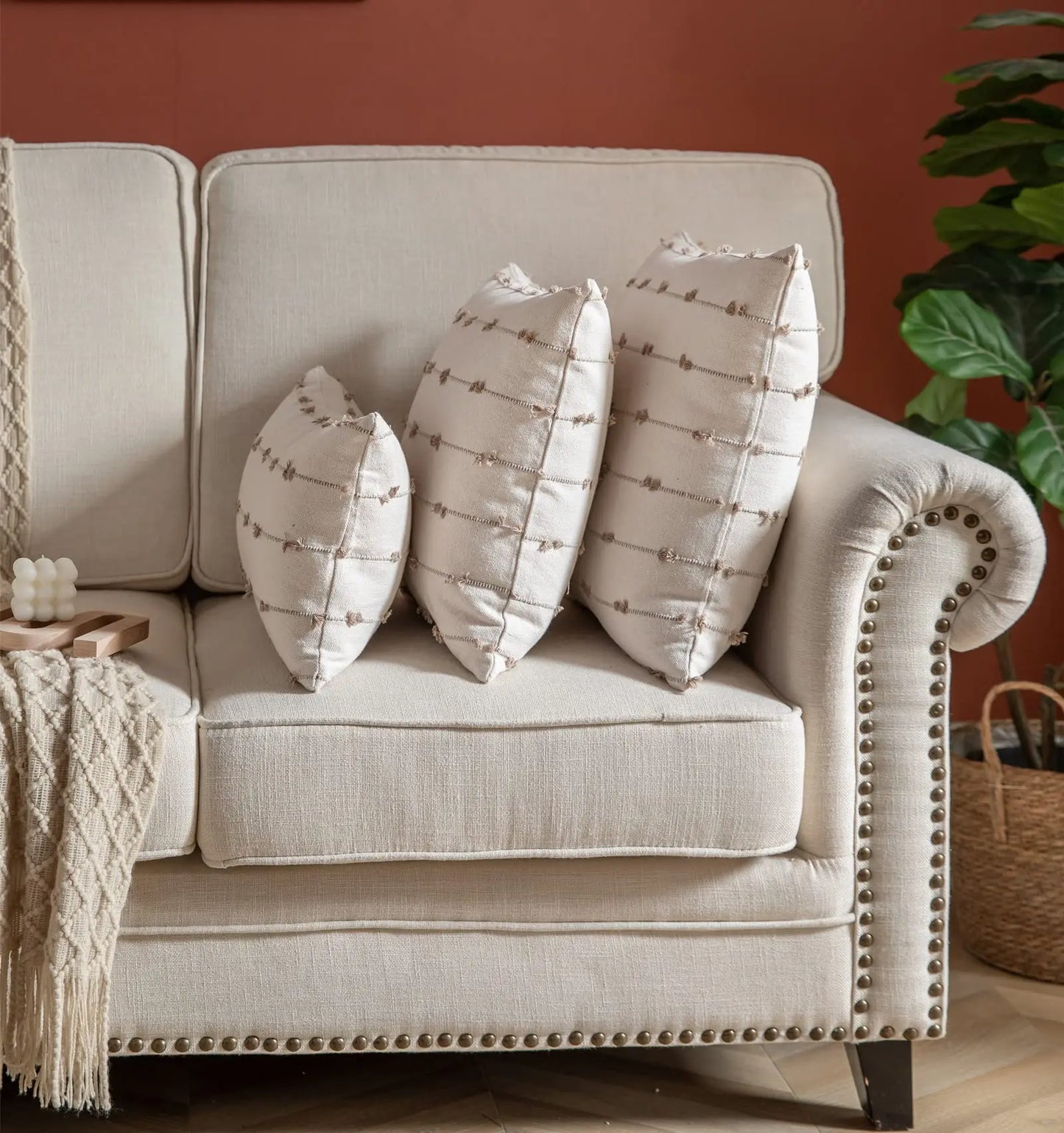 Beige sofa with patterned cushions against a red wall