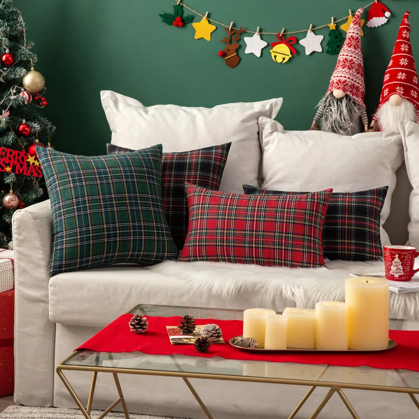 Decorated living room with Christmas-themed pillows, candles, and festive decorations.