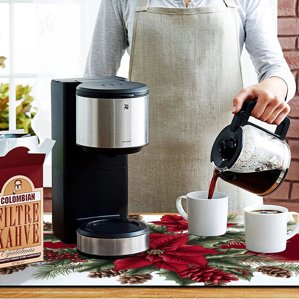 Person pouring coffee from a carafe into a cup next to a coffee maker on a festive tablecloth.