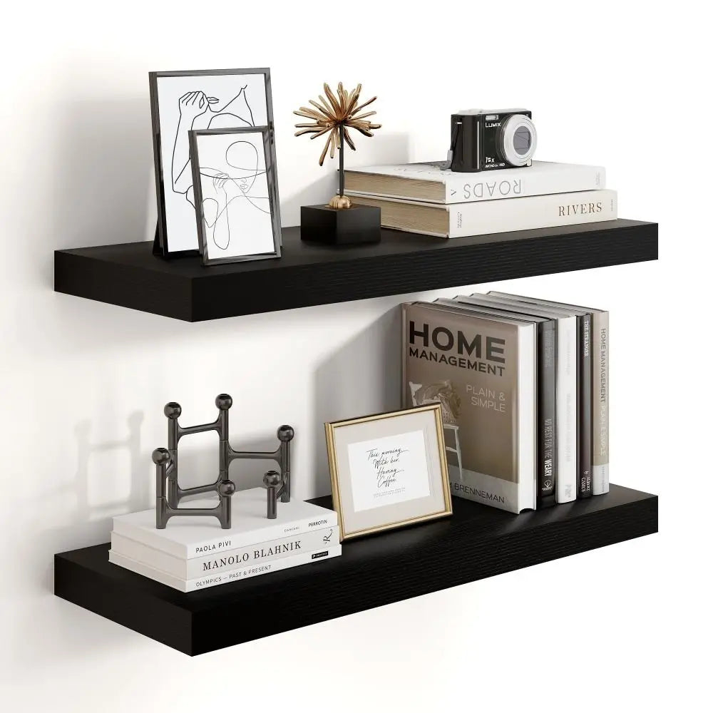 Black floating shelves with books, frames, and decorative items on a white wall.
