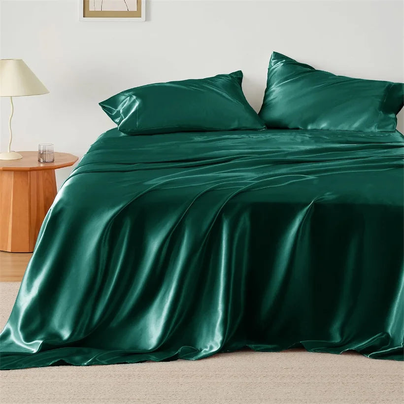 Green satin bedding set on a bed in a bedroom setting.